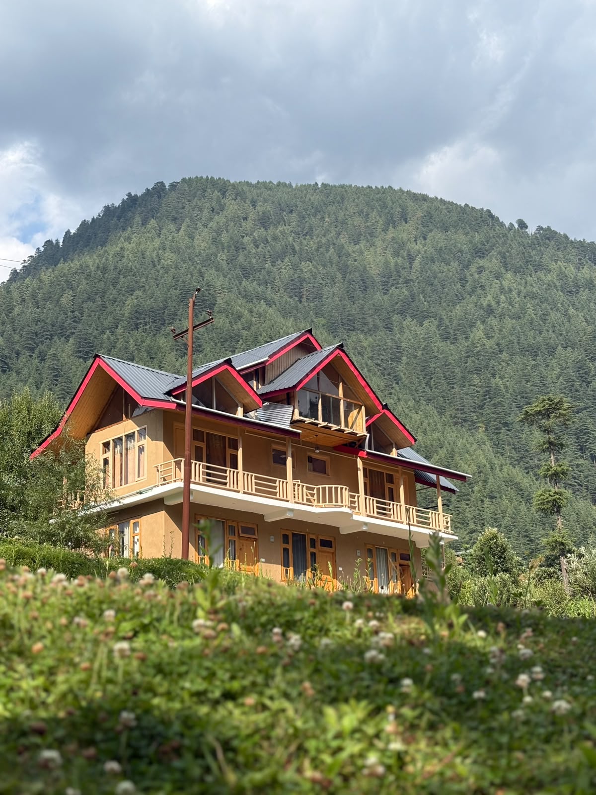Founders enjoying tea on a wooden balcony overlooking mountains
